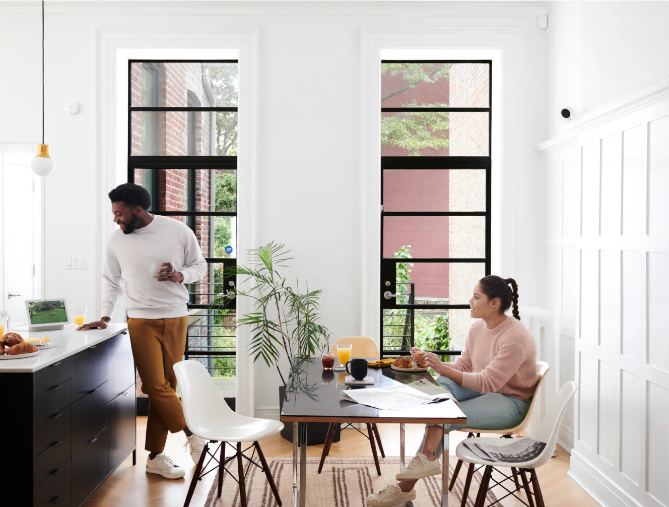Homeowners in a bright kitchen with smart home security devices